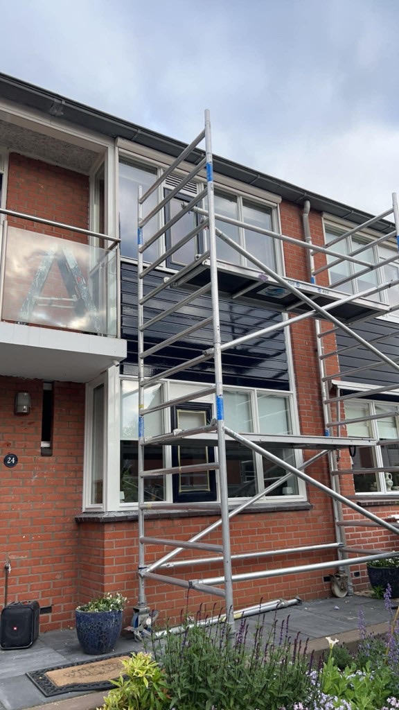 Buitenschilderwerk met steiger bij een woning